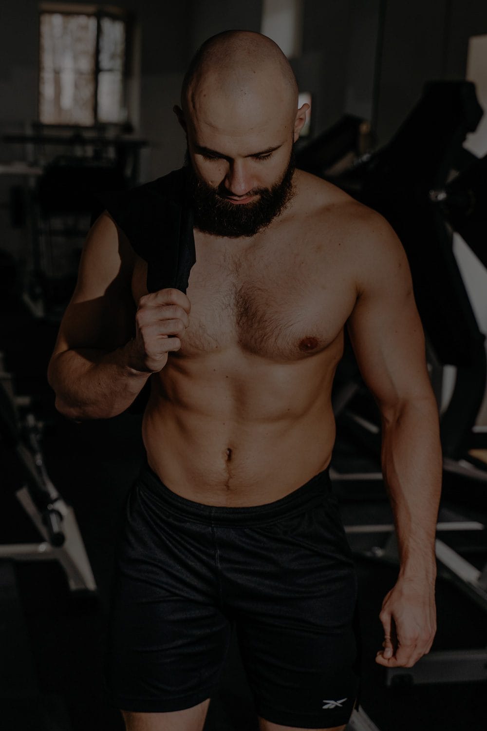 Fit man doing squats in gym – alt: strength workout for testosterone